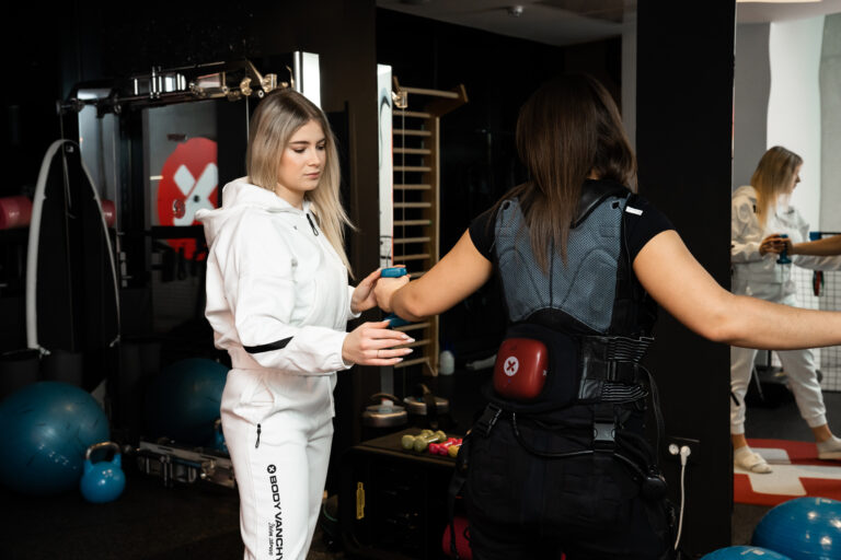 Osebna trenerka nadzoruje vaje v XBody obleki